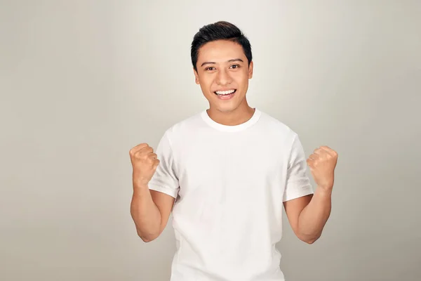 Успешный Эмоциональный Молодой Азиатский Мужчина Поднимает Сжатые Кулаки Воздух Чувствуя — стоковое фото