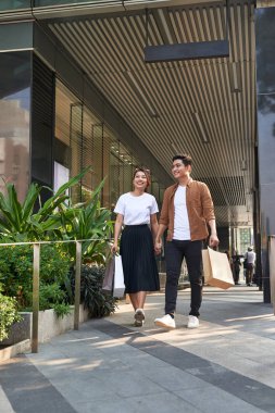 Güzel, genç bir çift alışveriş torbaları taşıyor ve birlikte eğleniyorlar.. 