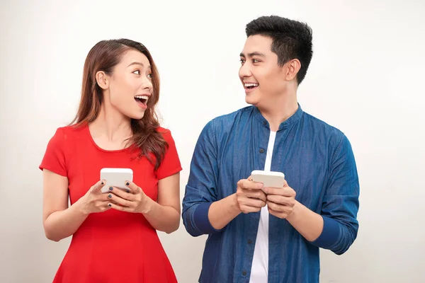 Belo Casal Moderno Sorridente Desgaste Casual Com Telefones Nas Mãos — Fotografia de Stock