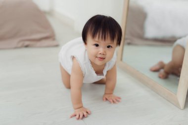 Odada katta sürünerek sevimli küçük bebek kız
