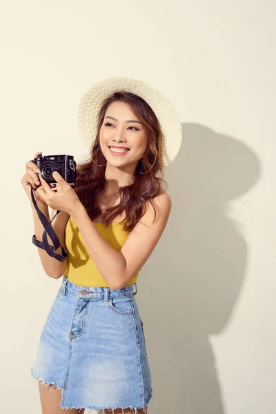 young pretty woman holding camera and wearing round hat