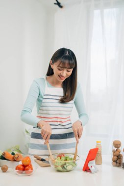 Mutfakta yemek hazırlarken mobil bakarak Pişirme kadın