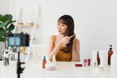 Bir blogger veya moda blogger veya vlogger aboneler için video kaydeder. Saçlara nasıl bakılabildiğini gösteriyor.