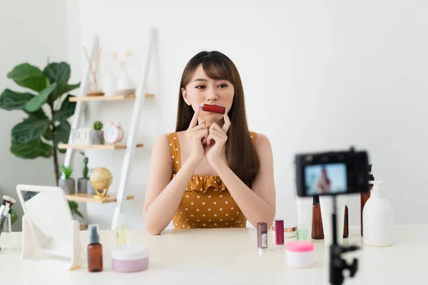 What is this. Pretty young woman sitting in front of the camera while testing cosmetics