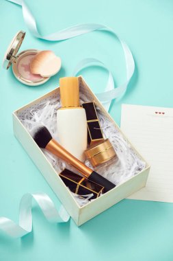 Makyaj ürünleri hediye kutusu üzerinde mavi arka plan ile görüntü