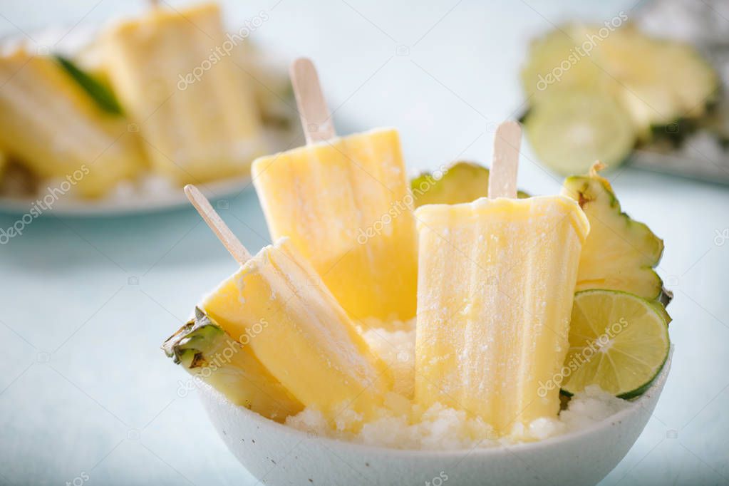 Some homemade Pineapple Popsicles (selective focus) on a rustic background