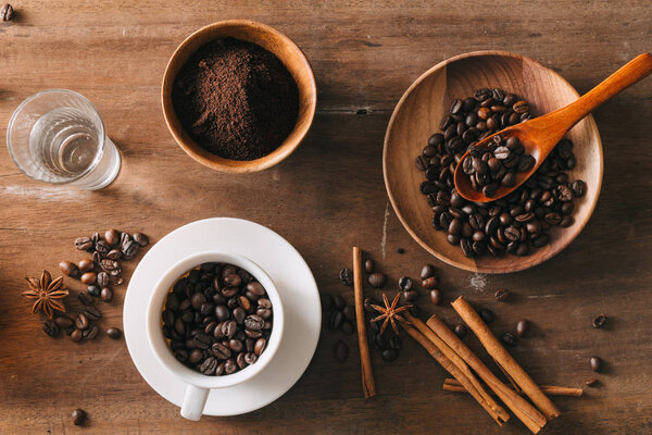 Black coffee in a cup on the background of coffee beans in a composition with accessories