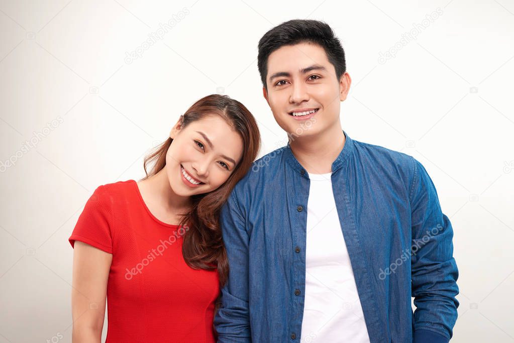 young asian couple leaning heads together over white background