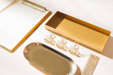 Hafif arka planda altın kırtasiye düz yatıyordu 