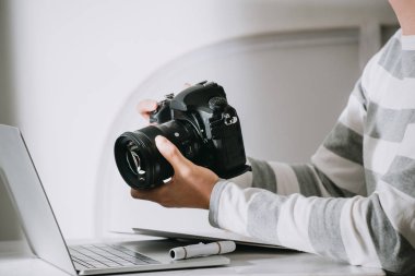 erkek fotoğrafçı onun fotoğraf stüdyosunda masanın üzerinde dijital kamera tutan