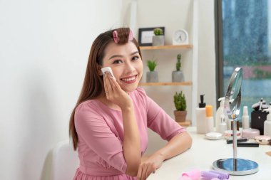 Kozmetik güzellik yordamlar ve baştan yaratma kavramı. Saç kadında curlers güzel pamuk kullanan genç kadın pedleri evde