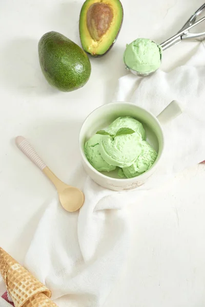 homemade organic avocado ice cream, with ice cream cones. On a grey stone table, copy space