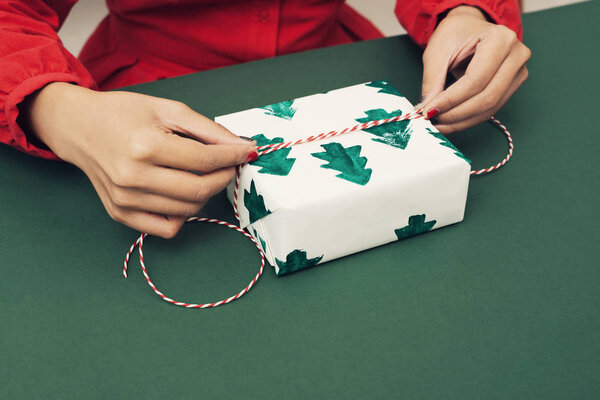 Closeup of woman's hands wrapping Christmas gift 