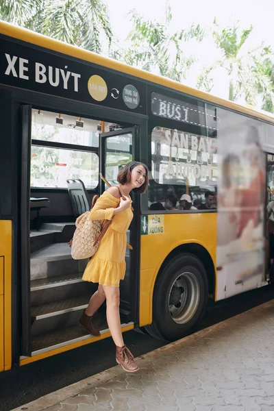 Beautiful young woman leaves the city bus