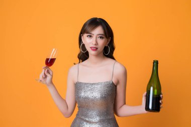 Sarı arka planda alkol ile parlayan elbise kadın.