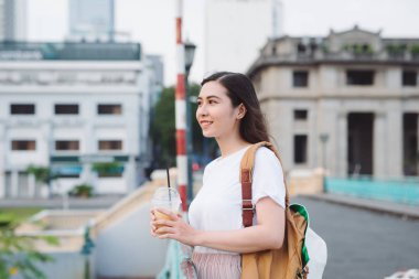 Genç sevimli kadın şehir arka plan üzerinde köprüde kahve içme