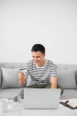 evde online alışveriş sırasında gülümseyen adam