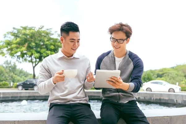 Two Men Using Tablet Computer Internet, Asian  Friends Guys Sitting at Cafe Natural Light