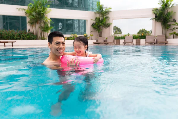 Happy family in swimming pool. Summer holidays and vacation concept