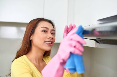 Beyaz mutfak dolap bir yüzey Temizleme çekici genç kadın portresi