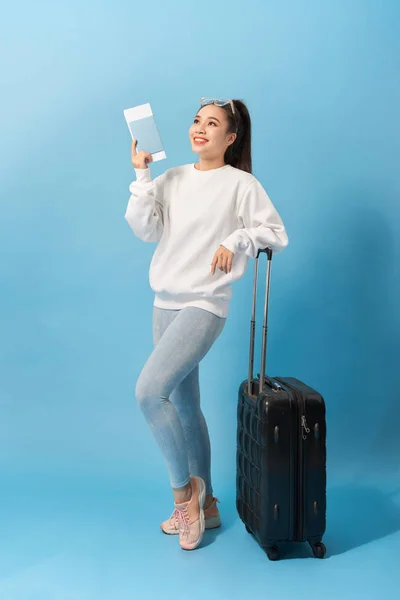 파란색 배경위에 티켓을 가지고 여행을 준비하는 캐주얼 쾌활한 여성의 이미지 — 스톡 사진