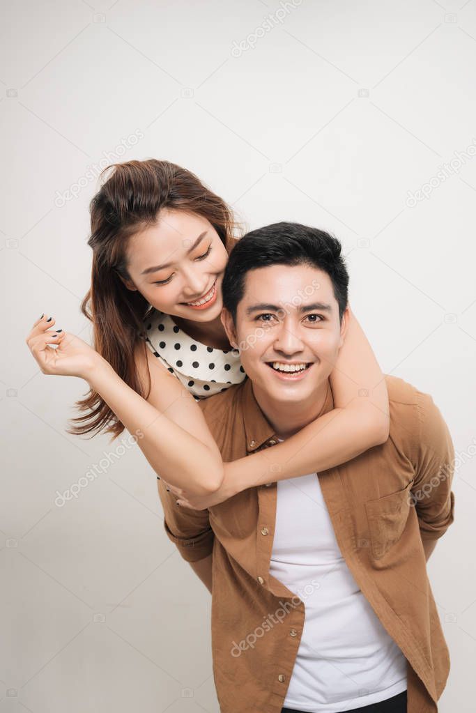 man carrying his lover on back, woman showing peace symbol over white background