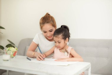Anne ve kızları ile Asyalı aile evde kağıt üzerinde çizim.