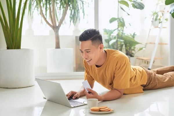 Bonito Jovem Segurando Cartão Crédito Sorrindo Usar Laptop Chão — Fotografia de Stock