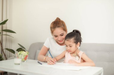 Anne ve kızları ile Asyalı aile evde kağıt üzerinde çizim.