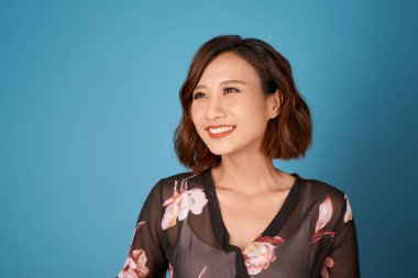 Açık mavi arka plan üzerinde odada duran kısa saç modeli ile Chilling kız.