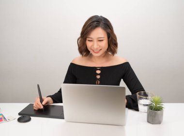 Bilgisayar ile çalışırken grafik tablet kullanarak Genç Asyalı kadın tasarımcı