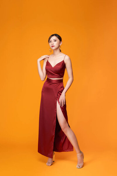 Elegant asian young woman in beautiful long dress posing in motion