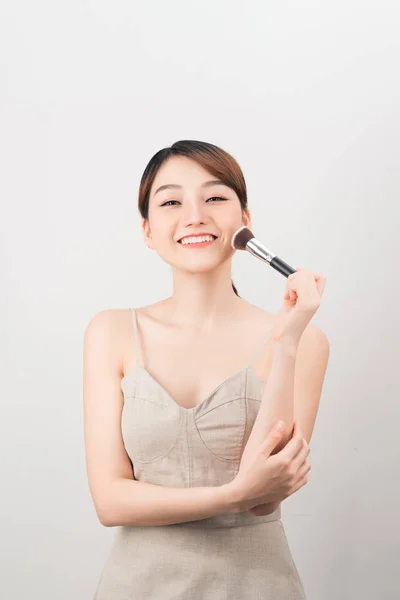 快乐的女人正在用刷子化妆 白色背景上的美容程序 — 图库照片