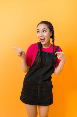 Asyalı kadın portresi renkli arka plan üzerinde bir şey işaret