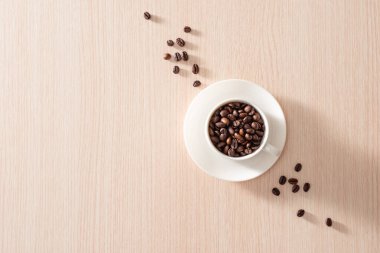 Ahşap arka plan üzerinde kavrulmuş fasulye ile Kahve fincanı