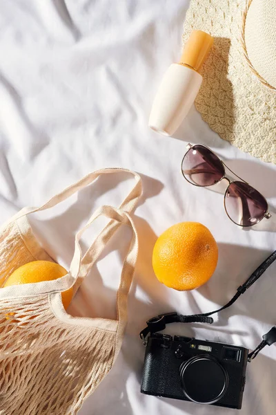 Flat lay Picnic, with glasses, an orange bag, sun cream and a straw hat with space. Summer mood