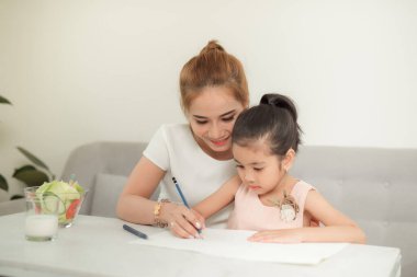 Anne ve kızları ile Asyalı aile evde kağıt üzerinde çizim.