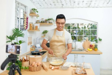 Yemek blogcusu canlı yayında. Adam abonelerle telefon kamerasıyla iletişim kuruyor.