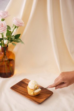 Kadın elleri masada lezzetli cupcakes kesti 