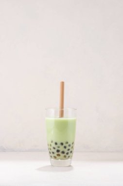 Beyaz arkaplanda saman olan yeşil çay bardakları.