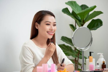 Genç güzel kadın ayna, Masa başında oturan yakınındaki makyaj yapma