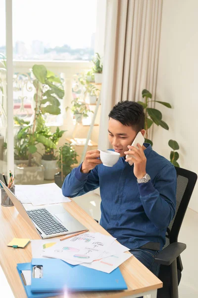Empresário Falando Telefone Enquanto Bebe Café Chá Sua Mesa Trabalho — Fotografia de Stock
