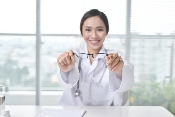 Female doctor working at office desk and smiling at camera