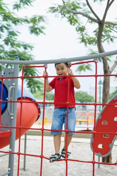 Young Asian Boy Climb Red Rope Fence Gray Bar His — Stock Photo, Image