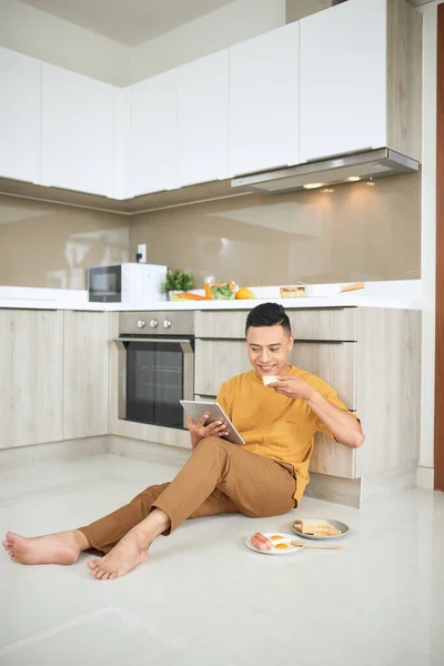 Asian young man work at home, an owner of online business, eating