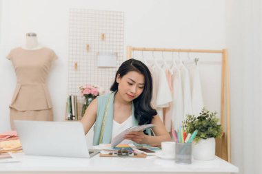Genç Asyalı moda tasarımcısı yeni koleksiyonu için renk seçiyor