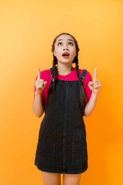 Asyalı kadın portresi renkli arka plan üzerinde bir şey işaret