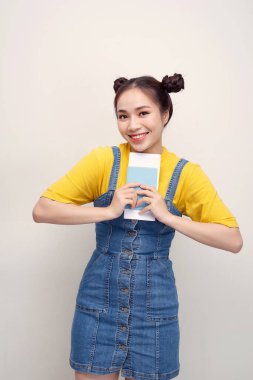 Beyaz arka plan üzerinde izole pasaport ve bilet tutarken kameraya bakan mutlu Afrikalı Amerikalı kadının Görüntü closeup