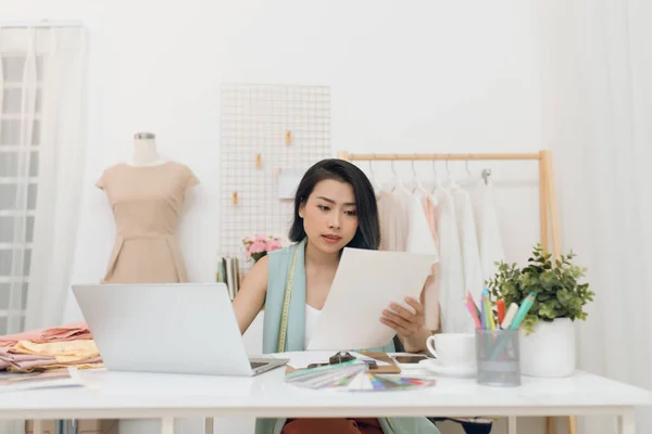 A business woman / Asian fashion designer working at her office / workshop