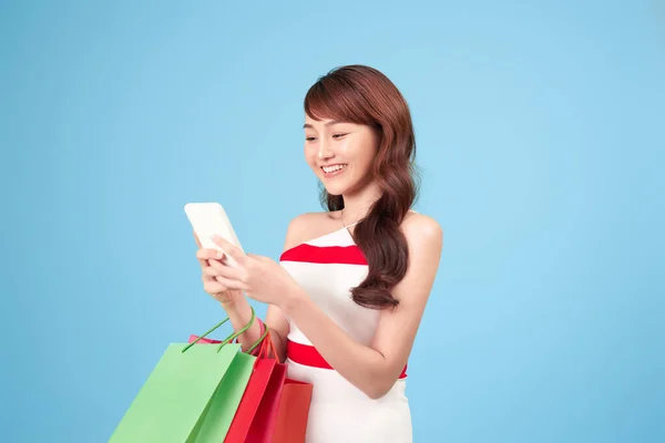 Beautiful Young Woman Using Smart Phone Shopping Online Isolated Blue Stock Image